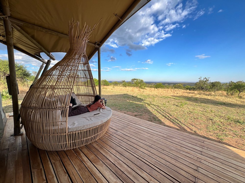 Rattan pod lounger on a private tent deck at Malaika