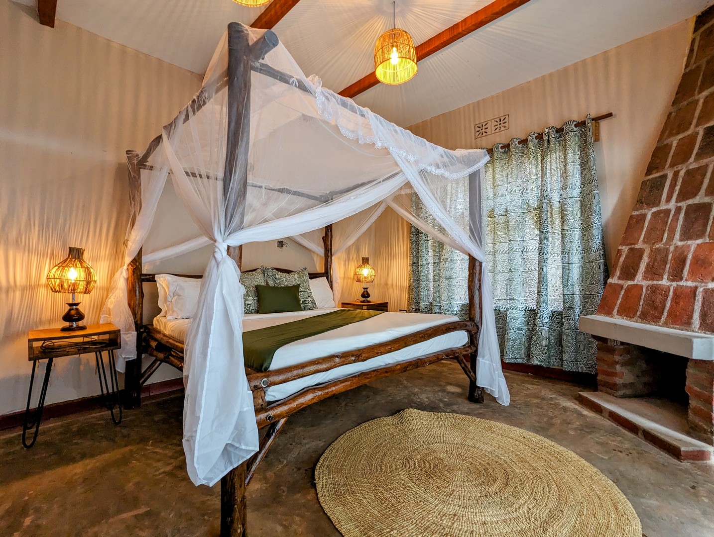 Canopy king bed with fireplace in a Mvuli Lodge cottage