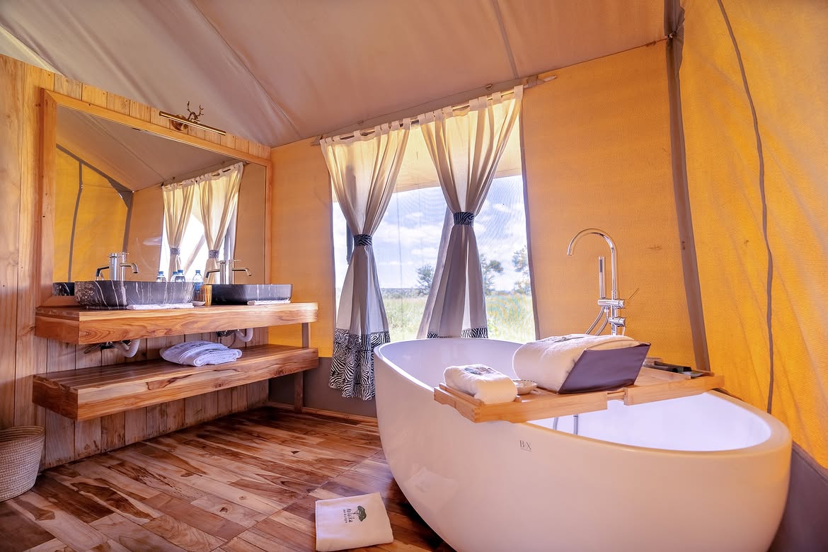 Ensuite tented bathroom with freestanding tub at Malaika
