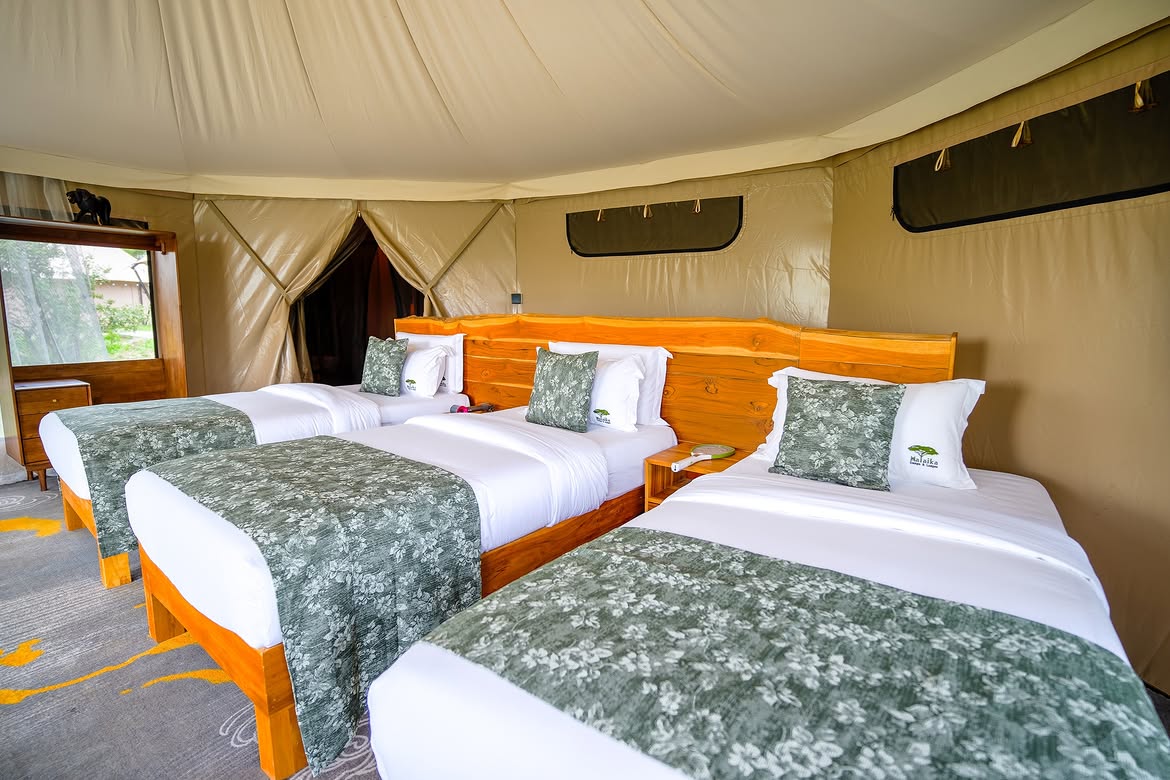 Family triple-bed tent at Malaika Camp with floral linens