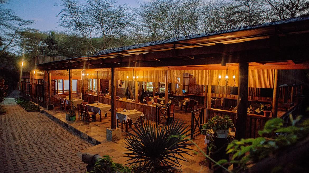 Warmly lit outdoor dining terrace at Under The Shade at dusk