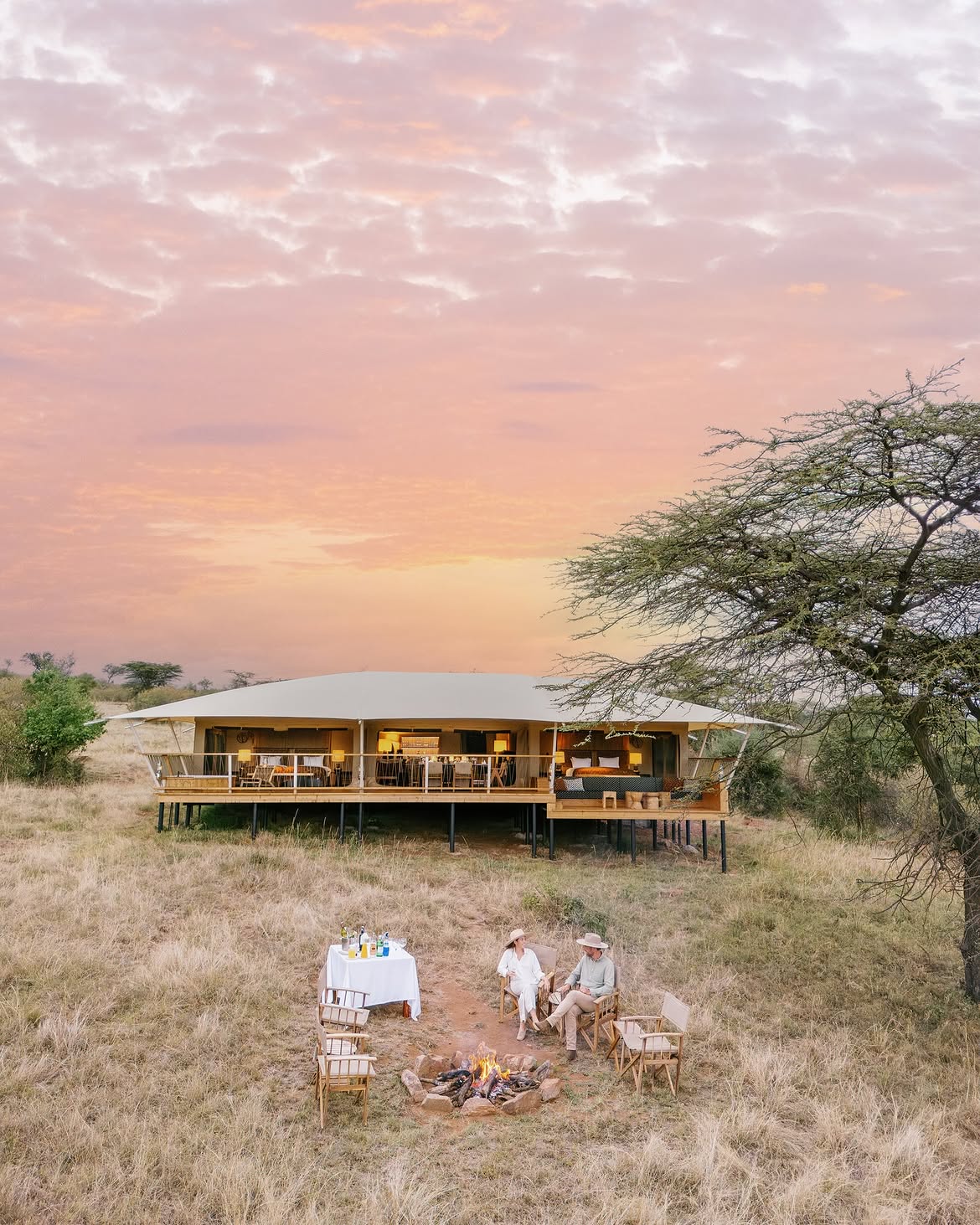 Bushtop tented suite at sunset with fire pit and acacia